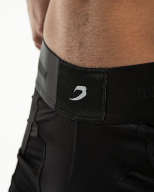 Man in black nylon slim fit boxers with white strike logo on waistband