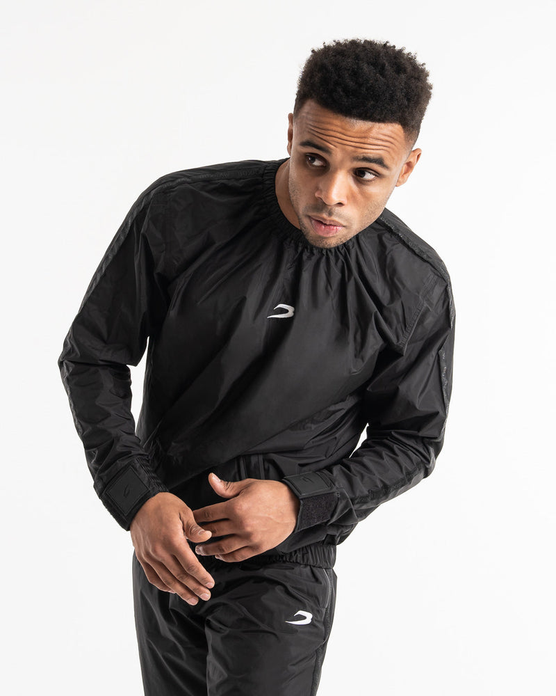 Man in a black sauna suit tracksuit with a white boxraw logo on the chest as well as adjustable wrist straps and made from polyester.