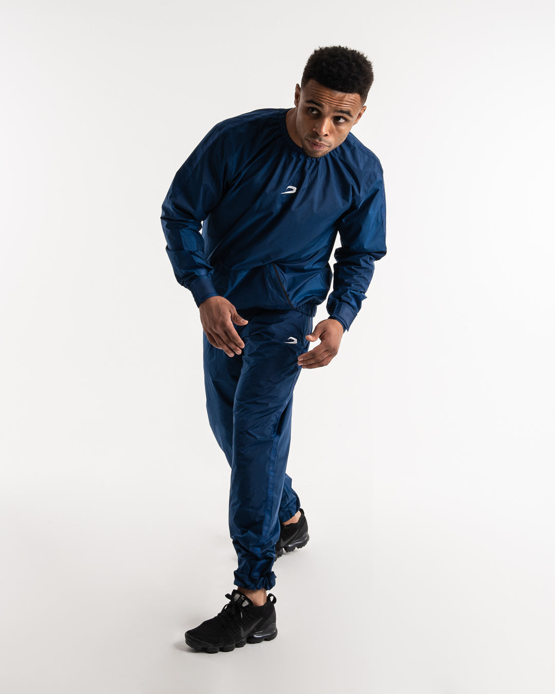 Man in a navy sauna suit tracksuit with a white boxraw logo on the chest as well as adjustable wrist straps and made from polyester.