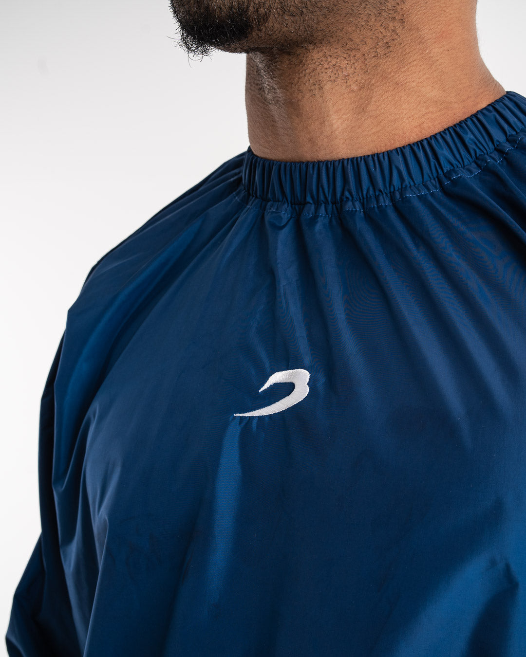 Man in a navy sauna suit tracksuit with a white boxraw logo on the chest as well as adjustable wrist straps and made from polyester.