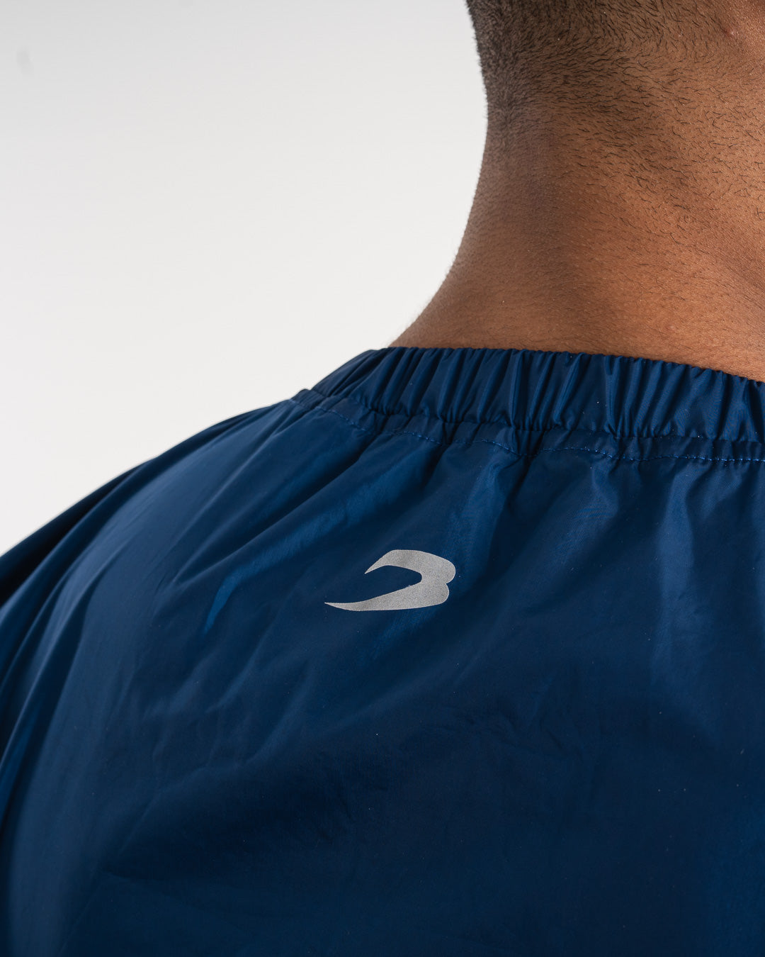 Man in a navy sauna suit tracksuit with a white boxraw logo on the chest as well as adjustable wrist straps and made from polyester.