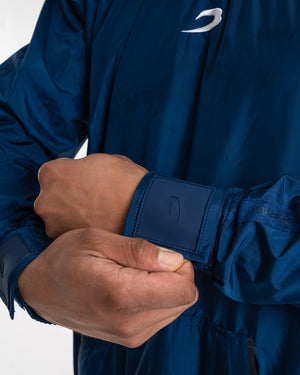 Man in a navy sauna suit tracksuit with a white boxraw logo on the chest as well as adjustable wrist straps and made from polyester.
