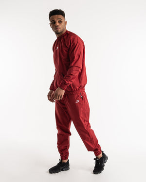 Man in a red sauna suit tracksuit with a white boxraw logo on the chest as well as adjustable wrist straps and made from polyester.