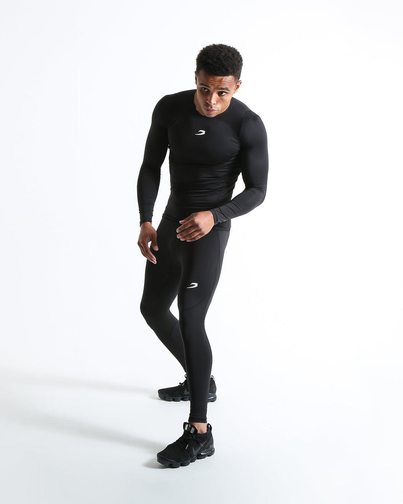 Man in black compression leggings/tights with wide elastic waistband and a white 3D strike logo on the leg.