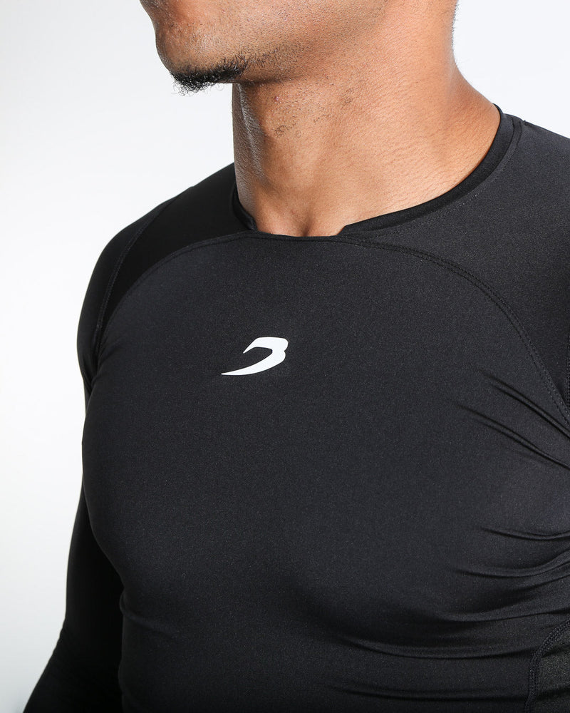 Man in black compression long sleeved t-shirt made from mesh fabric and targeted ventilation panels with white boxraw strike logo on the chest